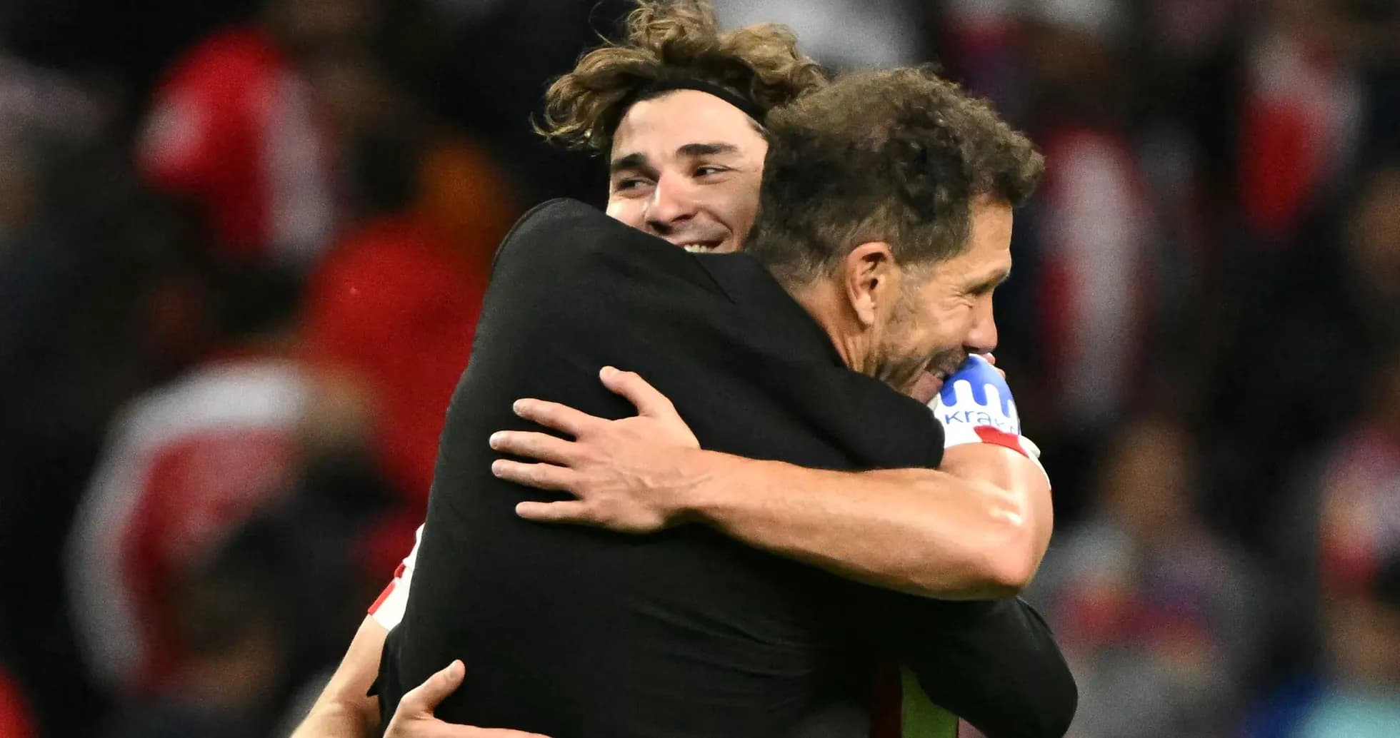 Deux personnes s'enlaçant après un match de football Deux personnes s'enlaçant après un match de football