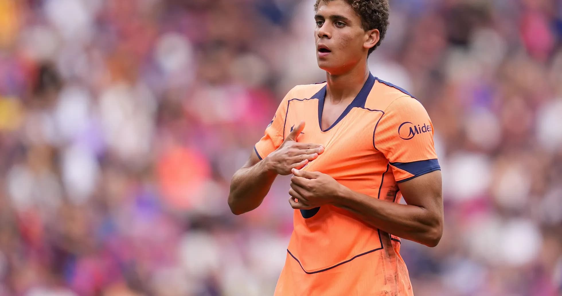 Joueur en maillot orange sur le terrain de football Joueur en maillot orange sur le terrain de football