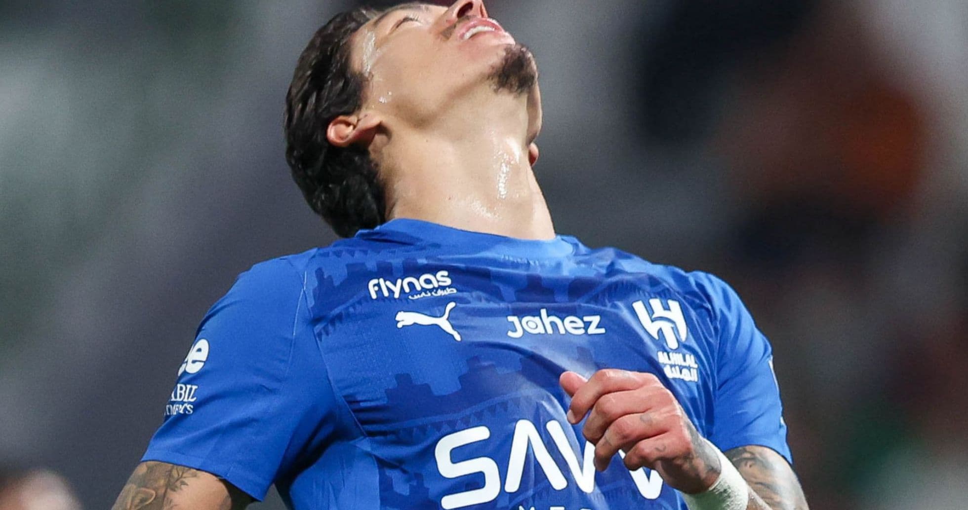 Joueur de football en maillot bleu, les yeux levés Joueur de football en maillot bleu, les yeux levés