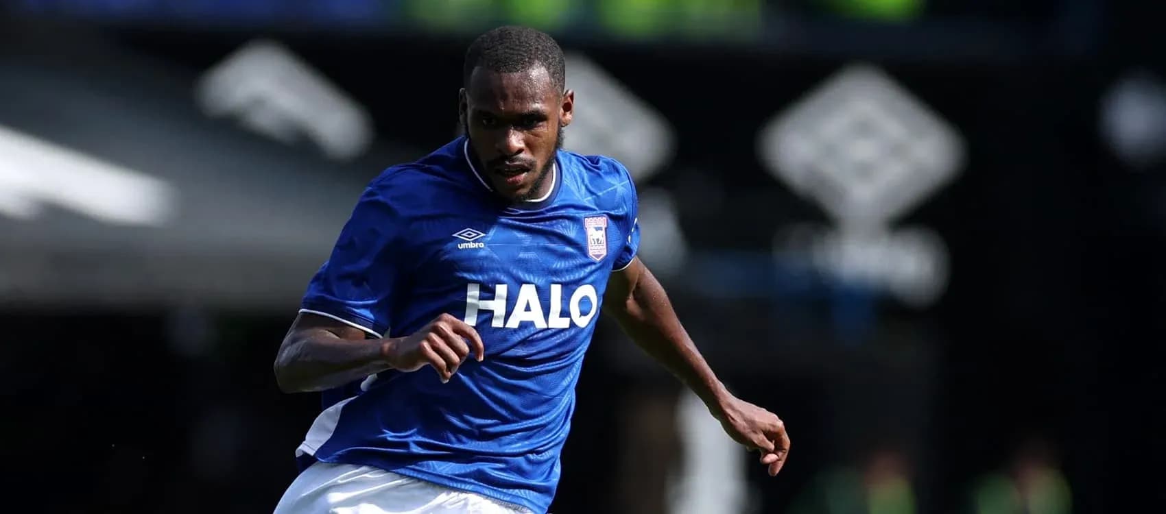 Joueur en maillot bleu courant sur le terrain Joueur en maillot bleu courant sur le terrain