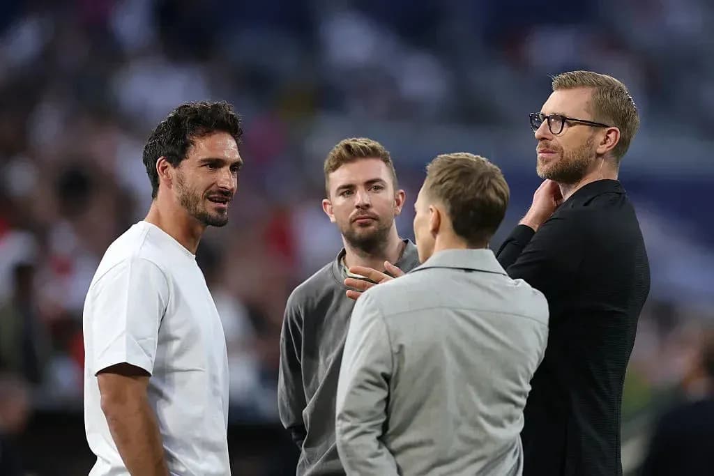 Quatre hommes discutant sur le terrain de football Quatre hommes discutant sur le terrain de football