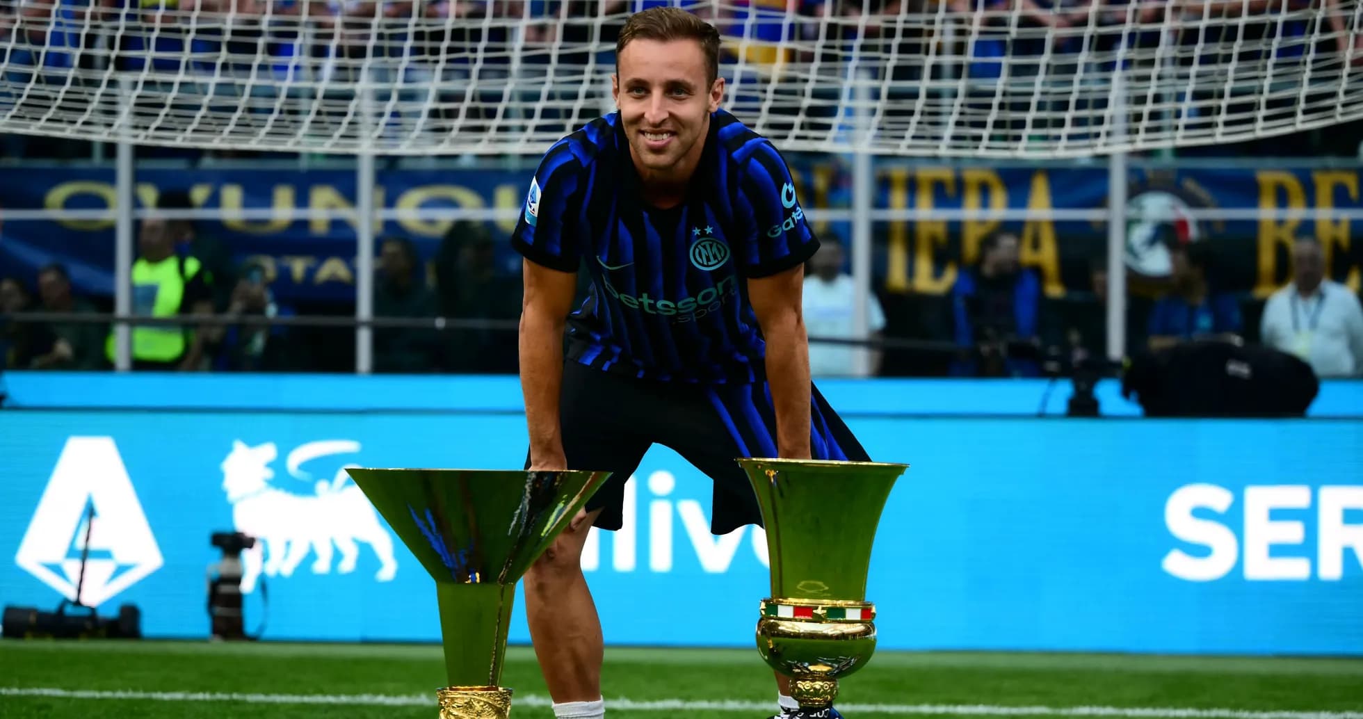 Joueur posant avec deux trophées sur le terrain Joueur posant avec deux trophées sur le terrain