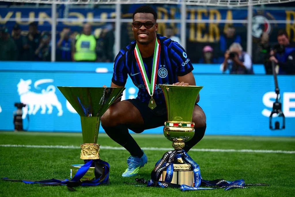 Joueur célébrant avec deux trophées de football Joueur célébrant avec deux trophées de football