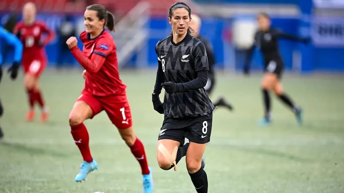 Joueuse en noir courant sur le terrain de football Joueuse en noir courant sur le terrain de football