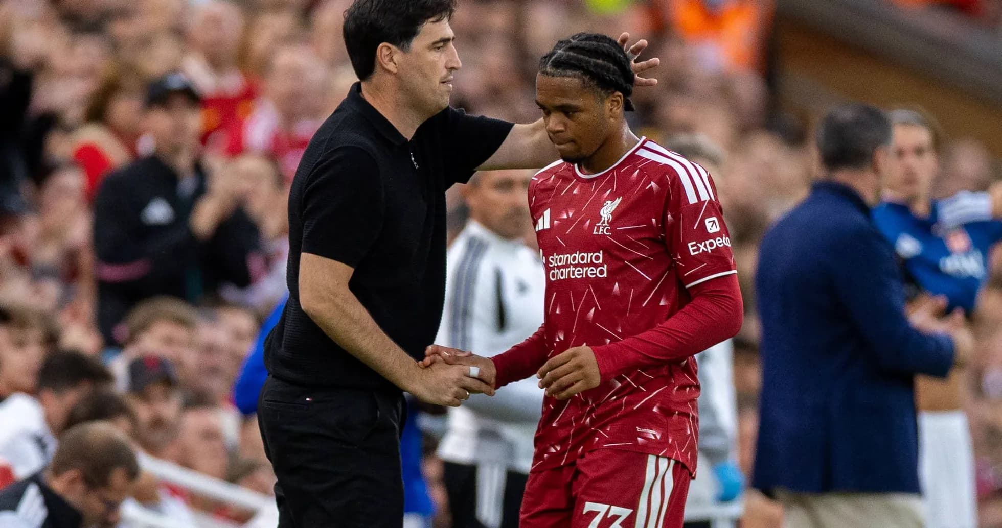 Entraîneur parlant à un joueur de Liverpool sur le banc Entraîneur parlant à un joueur de Liverpool sur le banc