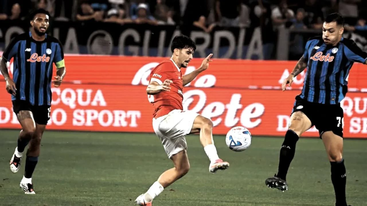 Joueur en rouge dribblant le ballon entre deux adversaires Joueur en rouge dribblant le ballon entre deux adversaires