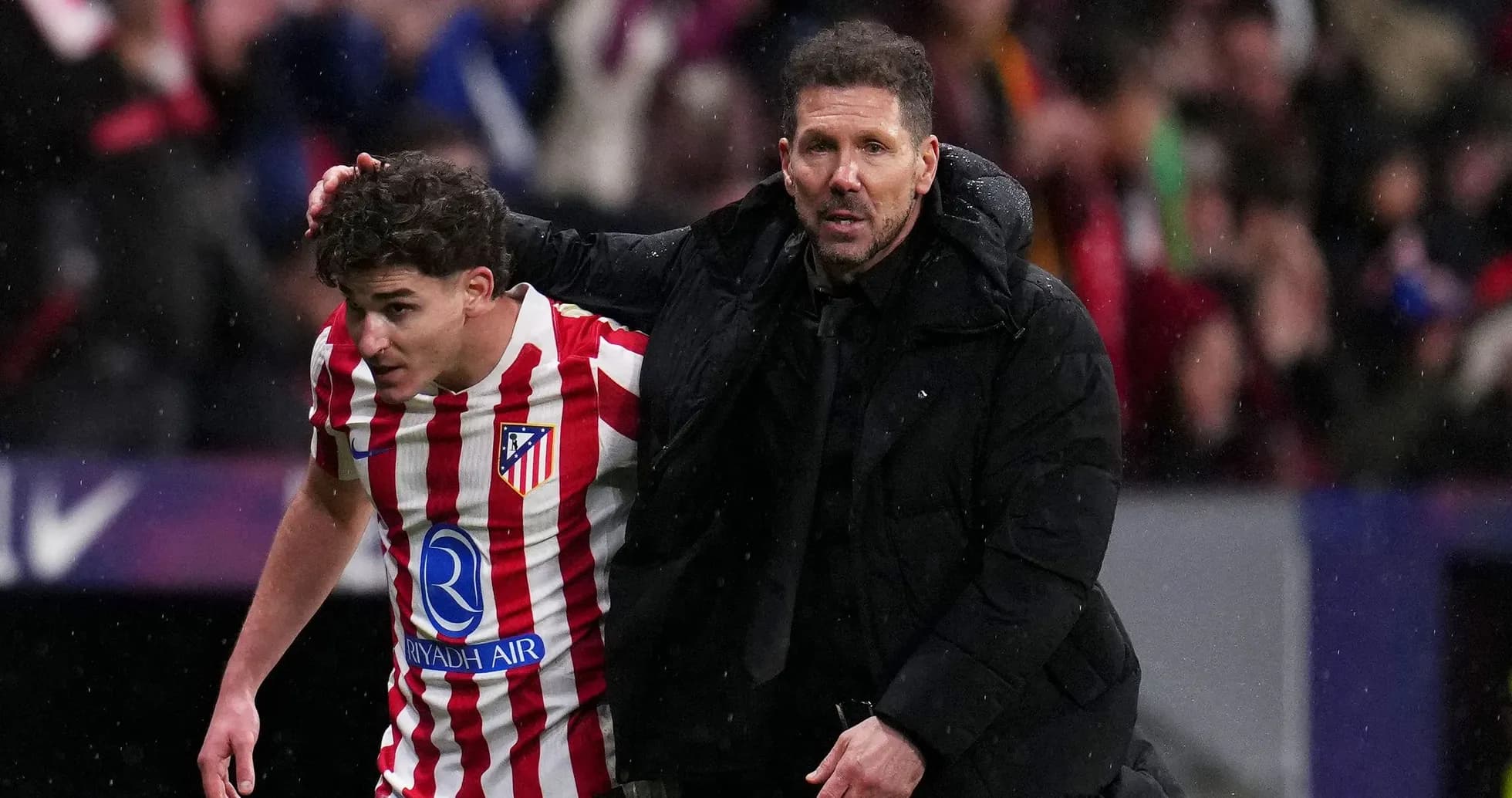 Entraîneur aidant un joueur d'Atlético sur le terrain Entraîneur aidant un joueur d'Atlético sur le terrain