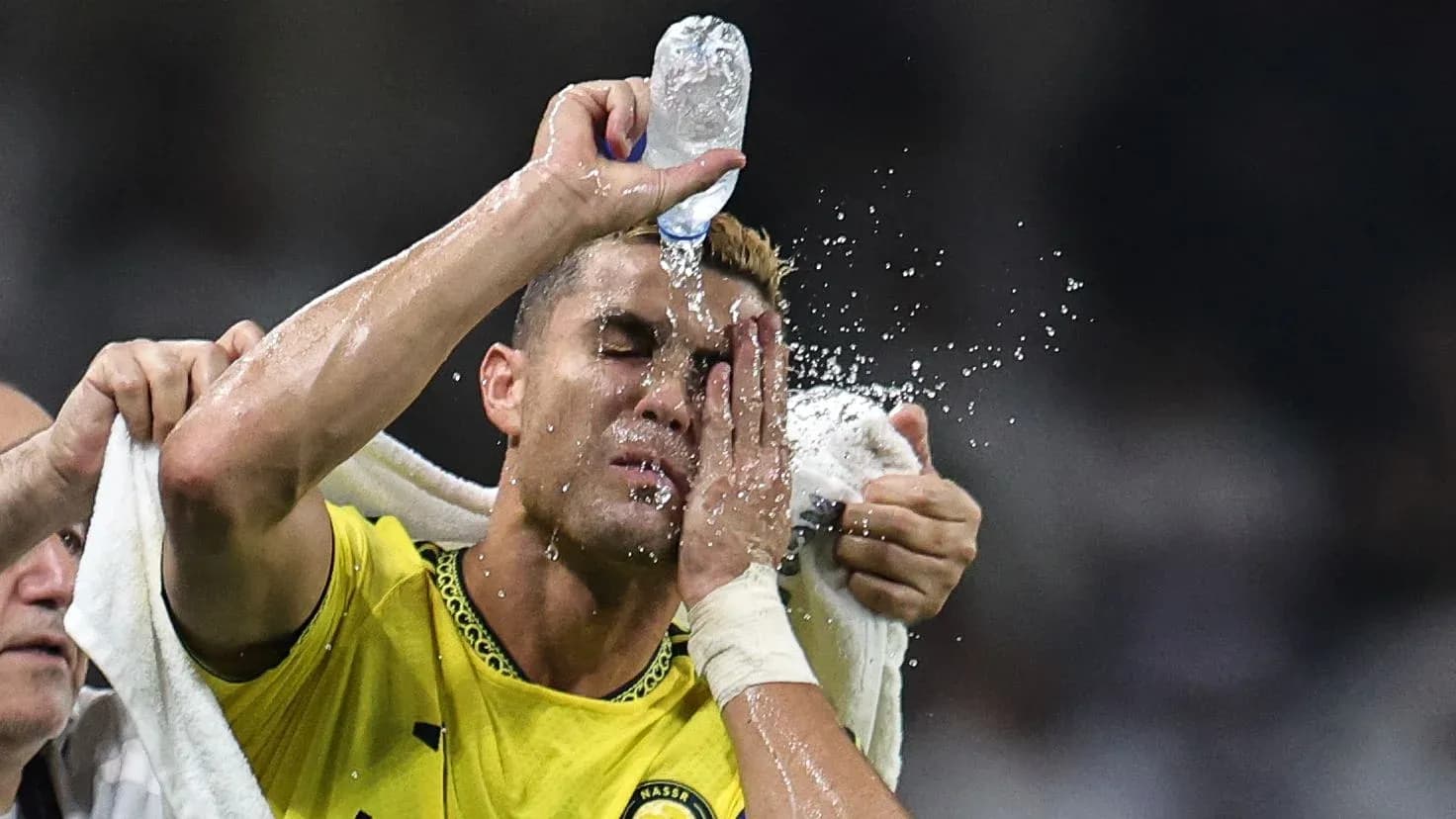 Joueur se rafraîchissant avec de l'eau pendant le match Joueur se rafraîchissant avec de l'eau pendant le match