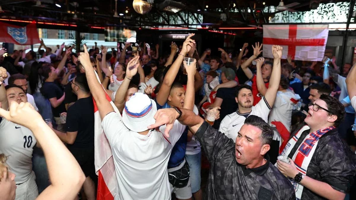 Supporters celebrating in a crowded pub during match Supporters celebrating in a crowded pub during match