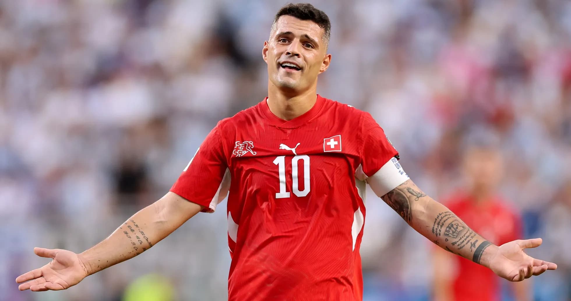 Joueur suisse en maillot rouge, bras levé en geste Joueur suisse en maillot rouge, bras levé en geste