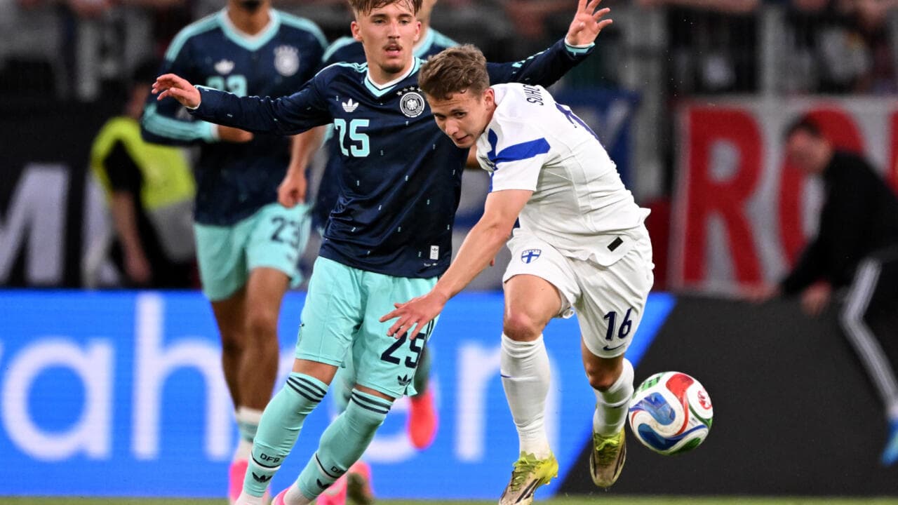 Joueur de Finlande dribblant sous pression allemande Joueur de Finlande dribblant sous pression allemande