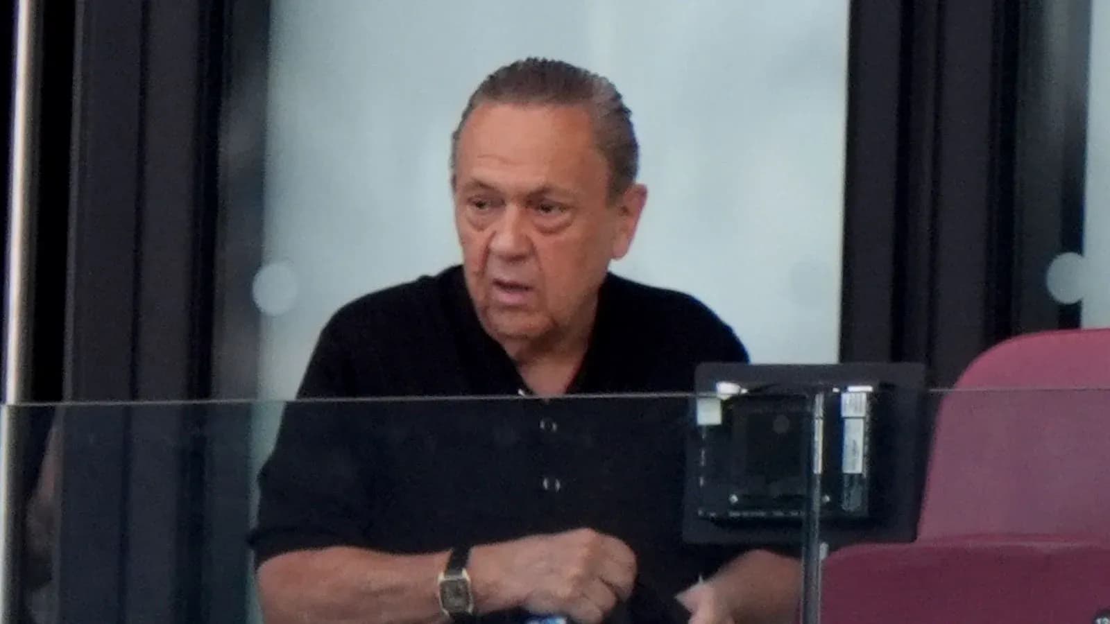 Homme observant depuis une loge au stade Homme observant depuis une loge au stade